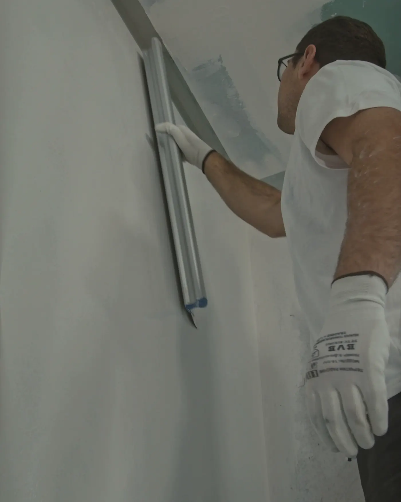Profissional fazendo o acabamento de uma parede de drywall